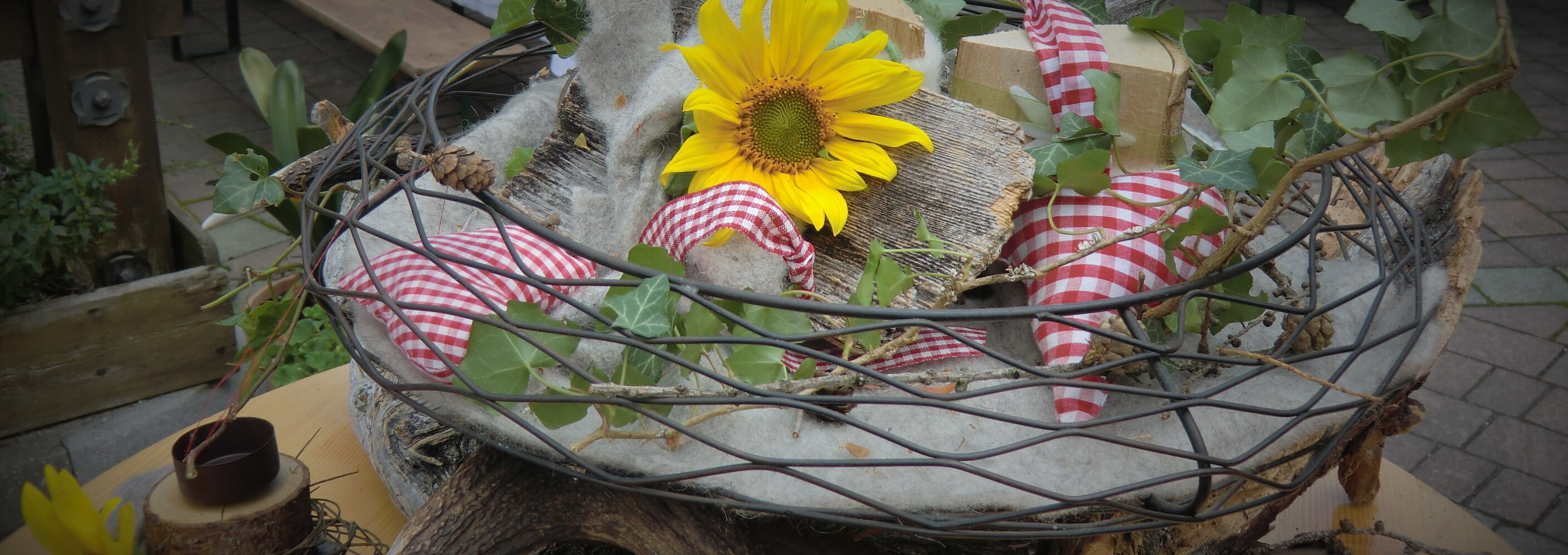 Rustikale Tischdekoration mit leuchtender Sonnenblume, Geweih und Stoffherzen im S' Mauthäusl Luftenstein.
