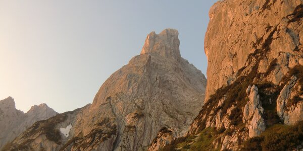Die markanten Felsgipfel der Loferer Steinberge leuchten im warmen Sonnenlicht im Saalachtal.