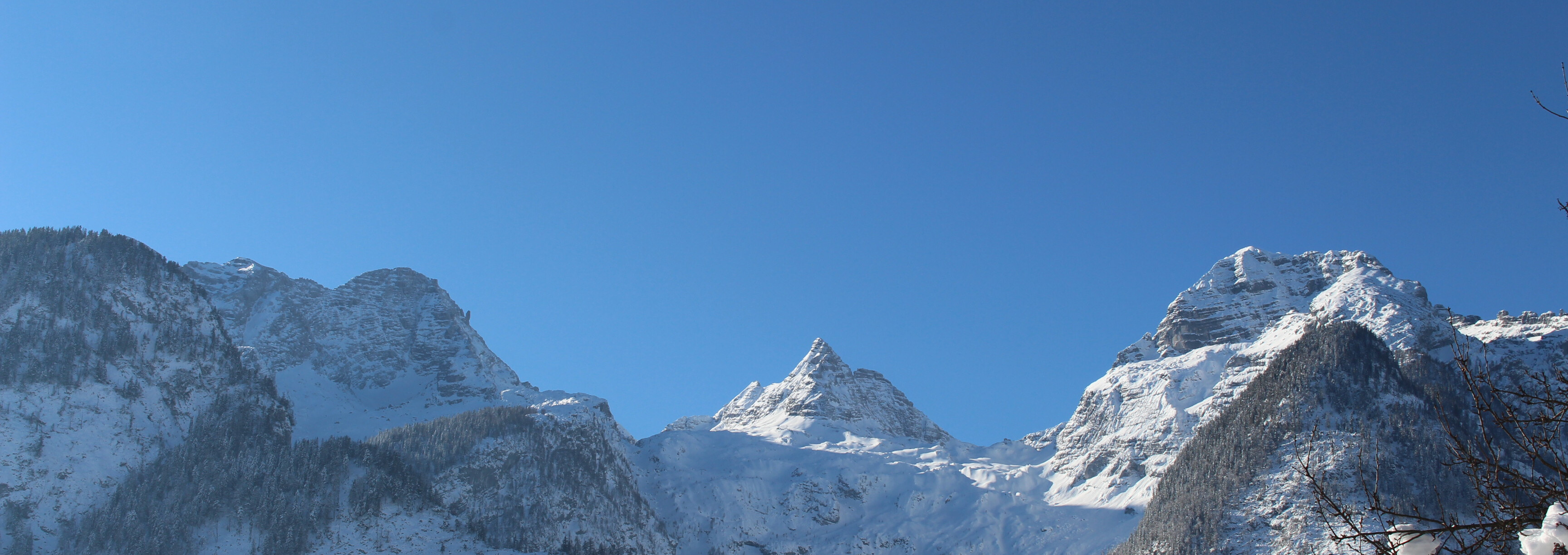 Verschneite Gipfel der Loferer Steinberge im Winter unter blauem Himmel im Saalachtal.