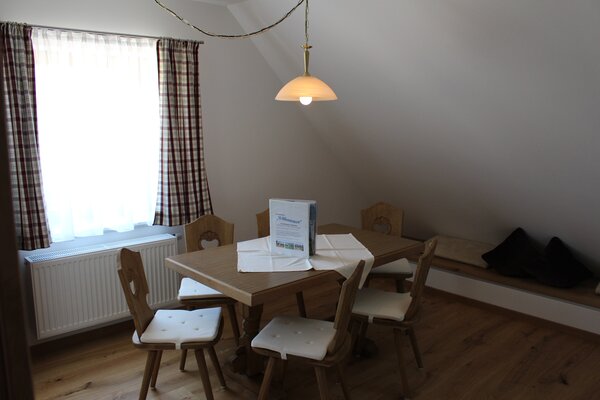 Gemütlicher Essbereich mit Holztisch und Stühlen in der Ferienwohnung Breithorn in St. Martin.