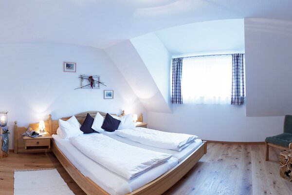Gemütliches Schlafzimmer der Ferienwohnung Breithorn mit Doppelbett und Dachschräge in Lofer.