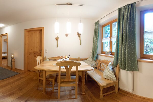 Gemütlicher Essbereich mit Holztisch und Eckbank in der Ferienwohnung Reifhorn in Lofer.