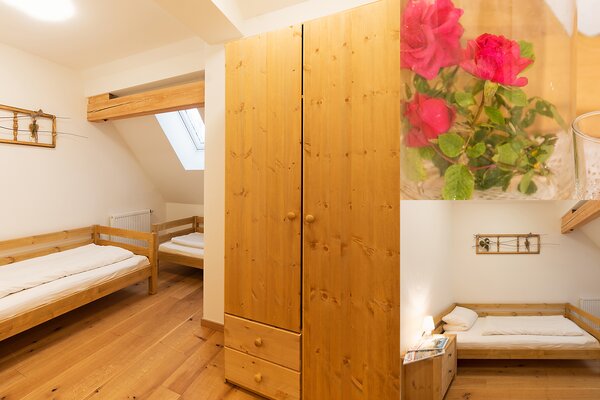 Gemütliches Schlafzimmer der Ferienwohnung Reifhorn mit Holzbett, Kleiderschrank und Dachfenster in Lofer.