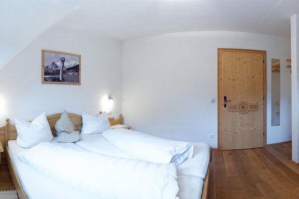 Gemütliches Schlafzimmer mit Doppelbett und Holzdetails in der Ferienwohnung Reifhorn in St. Martin bei Lofer.