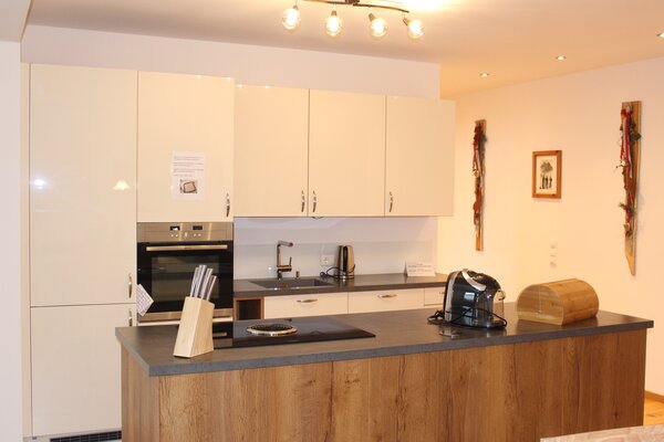 Moderne Küche mit Kochinsel und Backofen in der Ferienwohnung Schihörndl im S' Mauthäusl Luftenstein.