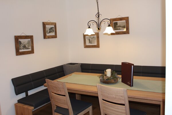 Gemütlicher Essbereich mit Eckbank und Holztisch in der Ferienwohnung Schihörndl im Mauthäusl Luftenstein.